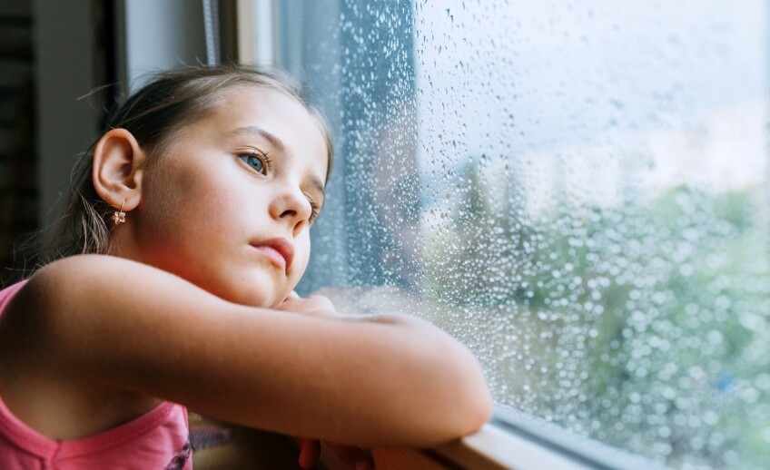 Little-sad-girl-pensive-looking-through-the-window-glass-with-a-lot-of-raindrops.-Sadness-childhood-concept-image.-1170879651_1258x839